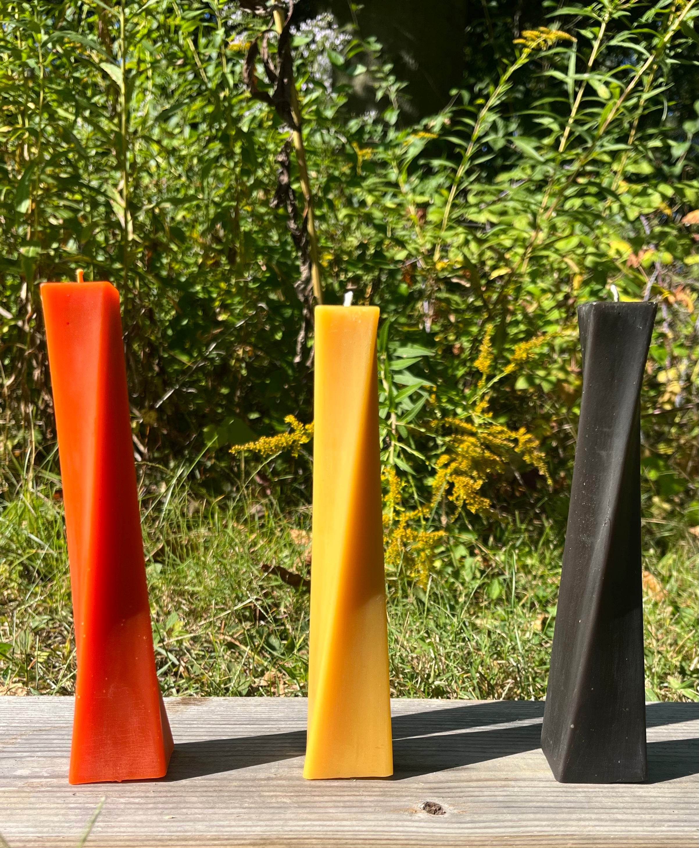 This beeswax candle is ready to shine for Halloween. The colors orange, black, and natural are shown.