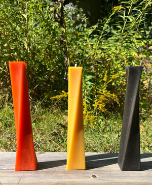 This beeswax candle is ready to shine for Halloween. The colors orange, black, and natural are shown.