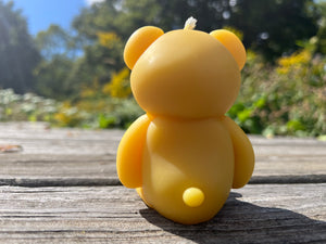 The behind view of the cuddle teddy bear beeswax candle.
