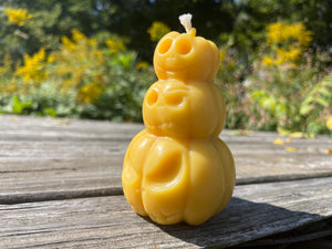 Beeswax candle of spooky pumpkins. Smile or frown for the lighter.