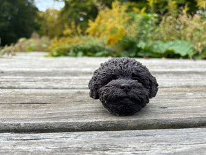 Black beeswax mold of a puppy.