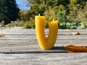 The blossom candle on display in the natural color of beeswax. 