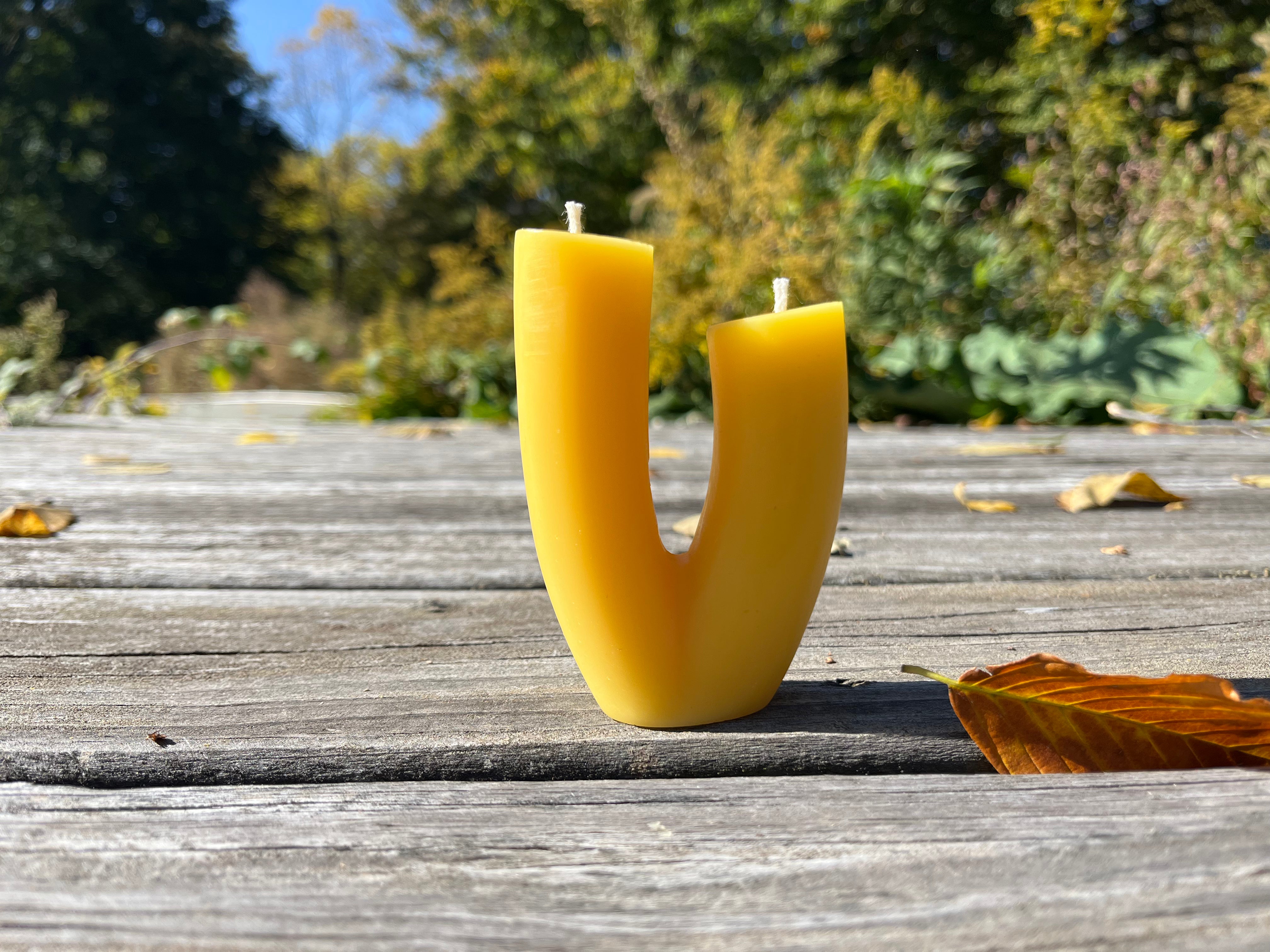 The blossom candle on display in the natural color of beeswax. 